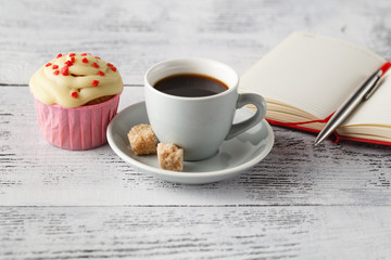 Cup of coffee and muffin on office table in begining of working