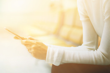 Obraz premium Woman at airport texting on a smartphone