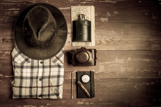 Des accessoires de randonn&eacute;e  avec chemise et chapeau sur des planches en bois en filtre s&eacute;pia