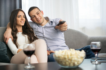 Young couple watching tv together at home.