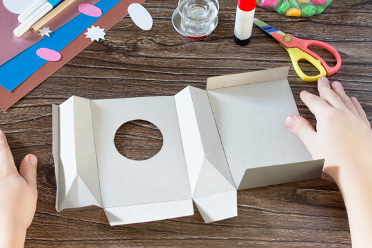 The child puts origami Easter greeting card packaging paper East