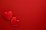 Two decorative hearts are on red paper. Flat lay.