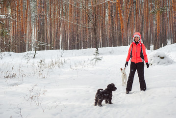 Portrait of the beautiful woman with dogs in the winter forest