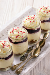 Cheesecake with cherry jelly in glass jars.