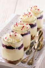 Cheesecake with cherry jelly in glass jars.