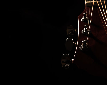 Closeup Of Acoustic Guitar Over Black Backgraound Shallow Depth Of Field
