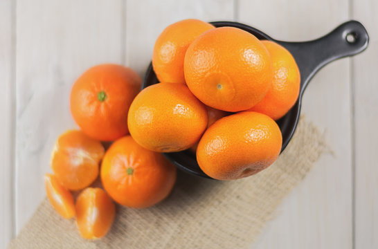 Group of tangerines on a wooden table.
