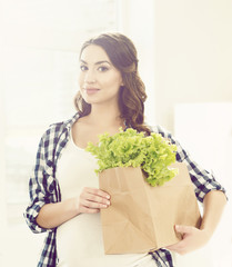 Pregnant woman with a shopping bag in the  kitchen