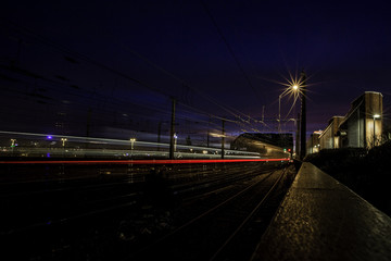 Befahrene Bahnlinie über die Hohenzollernbrücke in Köln bei Nacht