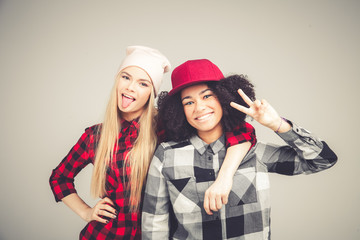 Studio lifestyle portrait of two best friends hipster girls going crazy and having great time together. Isolated on white background.