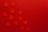 Decorative hearts are on red paper. Flat lay.