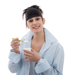 young brunette girl eats a yogurt on white