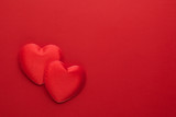 Two decorative hearts are on red paper. Flat lay.
