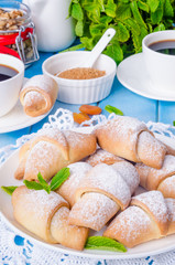 Mini croissants with dried apricots, figs and nuts on a plate