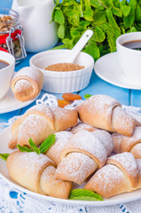 Mini croissants with dried apricots, figs and nuts on a plate