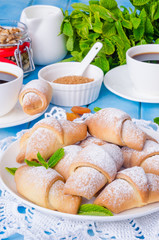 Mini croissants with dried apricots, figs and nuts on a plate