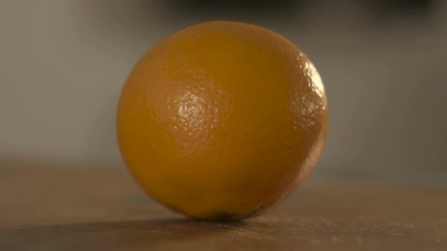 Orange fruit on wooden surface, sliding focus.