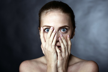 Scared girl covering her face with her hands