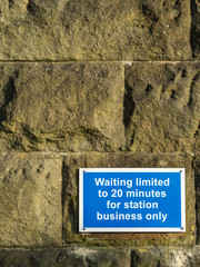 Waiting limited 20 minutes sign on stone wall