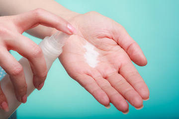 Woman putting white cream on hand