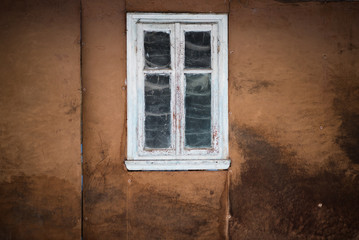 Fototapeta na wymiar the old window of the ancient house, dirty wall