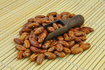 Brown pointed pinto beans on bamboo mat