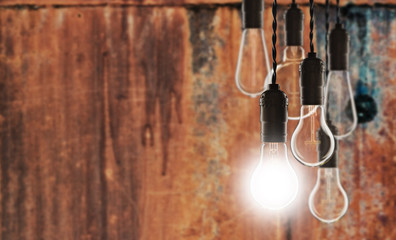 Idea and leadership concept - bulbs on the grunge background