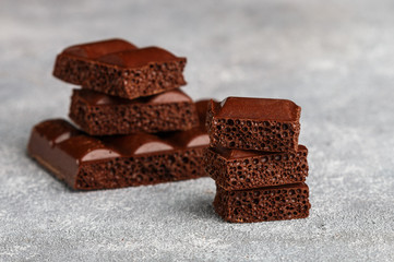 Porous milk chocolate, broken into pieces. Selective focus