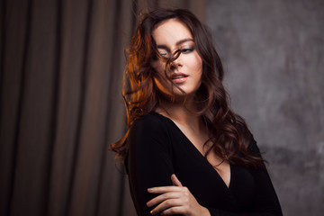 Delightful portrait of a woman brunettes, hair flying on the wind, sloppy styling