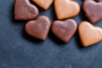 Chocolate hearts candies on black background Top view Copy space Valentines day postcard concept