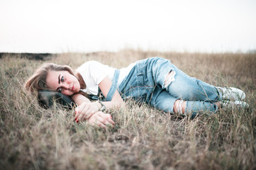 lifestyle, summer vacation, leisure and people concept - smiling young girl lying on grass