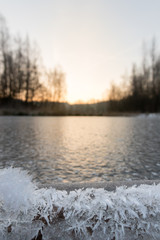 Low viewpoint on ice.
In the background a rising sun.
In the foreground artwork of ice crystals.