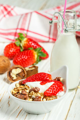 Homemade granola with fresh strawberries, yogurt and walnuts
