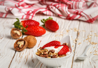 Homemade granola with fresh strawberries, yogurt and walnuts
