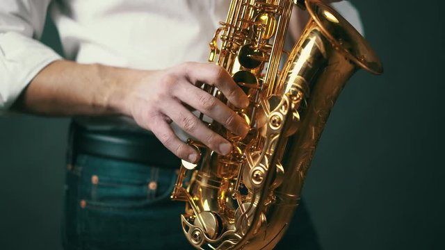 Close up shot of musician playing saxophone in studio.