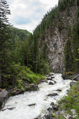 Fototapeta na wymiar Rough stormy river in rocky mountains
