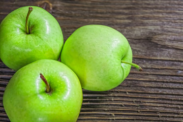 Ripe green apples on wooden background