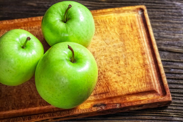 Ripe green apples on wooden background
