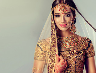 Portrait of beautiful indian girl. Young hindu woman model with golden kundan jewelry set ....