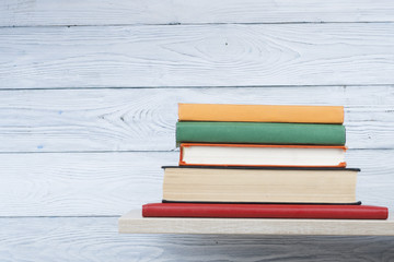 Stack of books on wooden shelf. Education background. Back to school. Copy space for text.