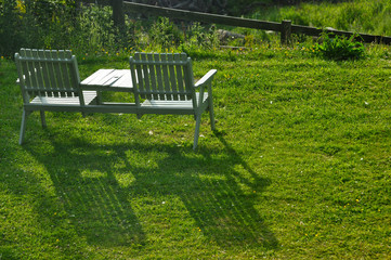 Vacant bench sitting in the setting sun with long shawdow