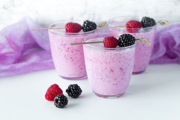 Fototapeta na wymiar Fresh berry smoothie set of three glasses with blackberry and raspberry for healthy breakfast on white background