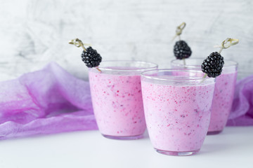 Fresh berry smoothie set of three glasses with blackberry and raspberry for healthy breakfast on white background