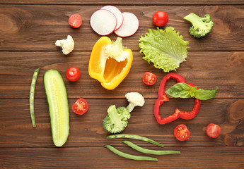 Fresh vegetables on wooden background, top view