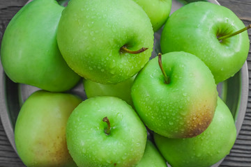 Ripe green apples on wooden background