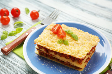 Portion of tasty lasagna on wooden table