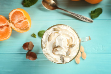Fresh pumpkin smoothie with oranges on wooden background
