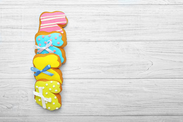 Colourful tasty Easter cookies in a row on white wooden background