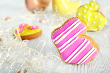 Creative rabbit shape Easter cookie and decorations on wooden table, closeup