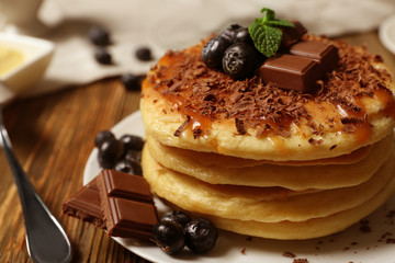 Stack of fresh pancakes with chocolate on plate